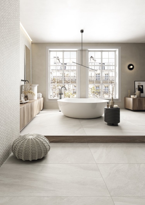 Badezimmer Limequartz weiß Blick auf luxuriöses Badezimmer mit zentraler Wanne, großen Fenstern im Hintergrund und Sitzgelegenheiten