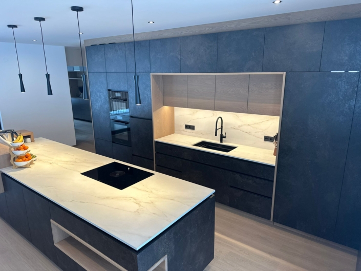 blaue Kücheninsel mit Herd und eingebauter Abwasch dahinter