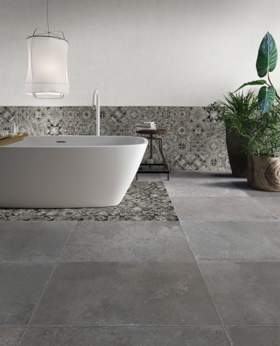 Modernes Badezimmer graue Fliesen Medi Medi-Badezimmer mit Badewanne inkl. Beleuchtung links und Pflanzen rechts und grauen Fliesen