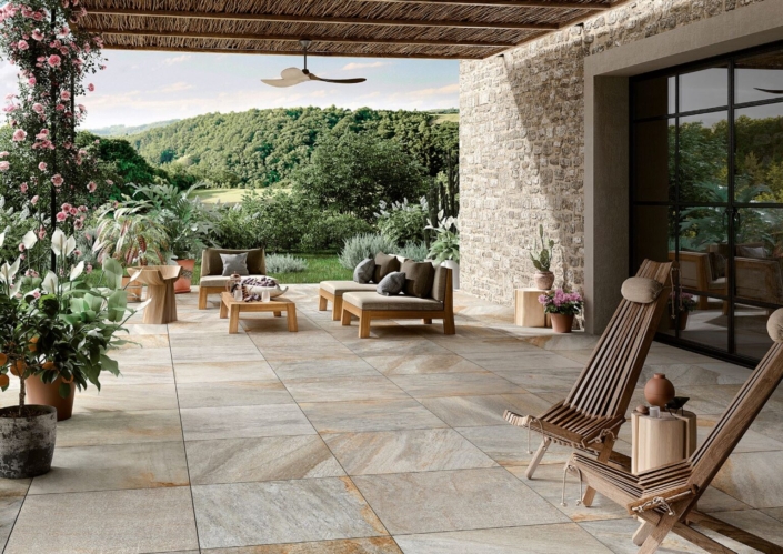 Terrasse mit Liegen und Tisch mit Garten im Hintergrund